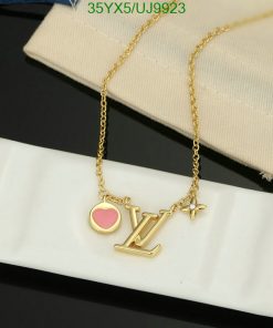 Gold pendant necklace with heart and letters on display.