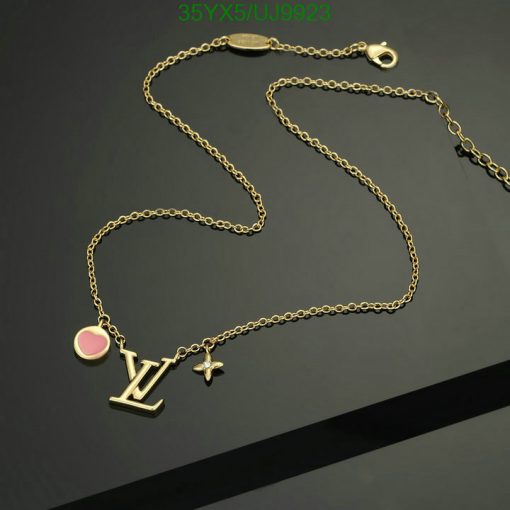 Gold charm necklace on dark background