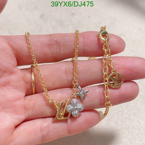 Gold pendant necklace with floral design on hand