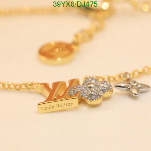 Gold designer logo necklace with flower and sparkle detail.