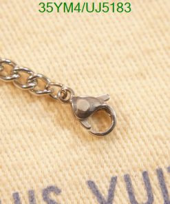 Silver clasp of chain on beige fabric background.