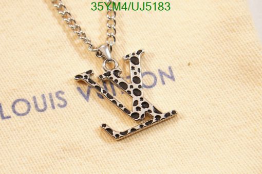 Designer monogram pendant on chain on branded background.