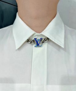 Silver chain necklace with blue pendant on white collar.