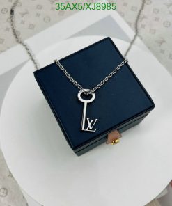 Designer key pendant necklace on blue box.