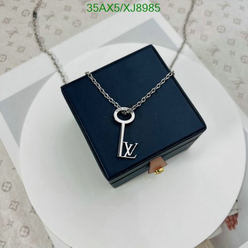 Designer key pendant necklace on blue box.