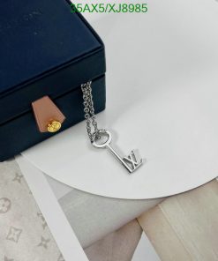 Designer key pendant necklace beside luxury box.