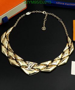 Designer gold-tone choker necklace on black surface.