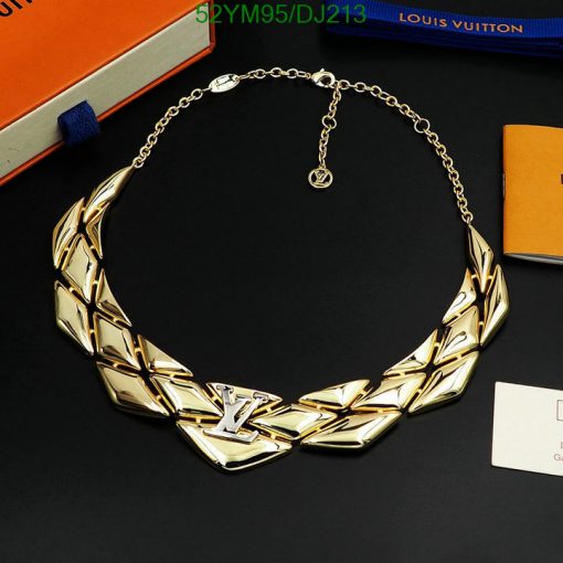 Designer gold-tone choker necklace on black surface.