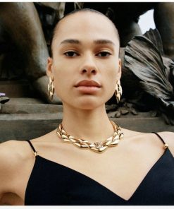 Model wearing Louis Vuitton jewelry and black top.