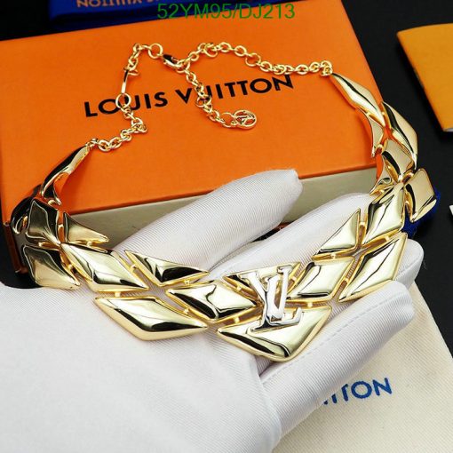 Gold designer necklace on display with branded box.