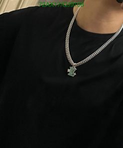 Person wearing black shirt with pendant necklace.