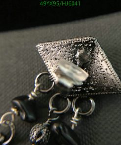 Close-up of textured silver jewelry with pearl detail.