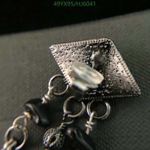 Close-up of textured silver jewelry with pearl detail.