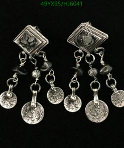 Silver chandelier earrings with coin dangles on black background.