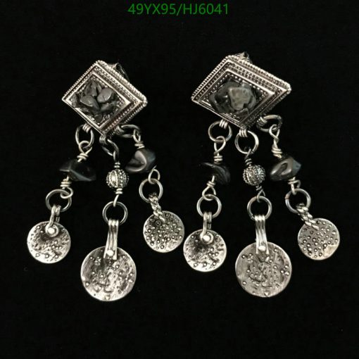 Silver chandelier earrings with coin dangles on black background.