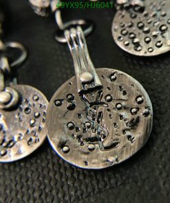 Textured silver earrings on black background.