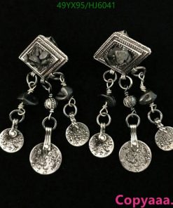 Silver chandelier earrings with coin charms on black background.