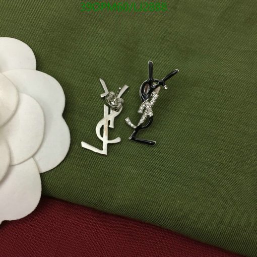 Silver and black fashion earrings on green fabric.