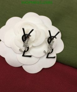 Diamond-studded letter earrings on white floral display