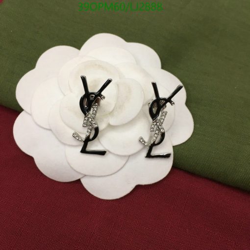 Diamond-studded letter earrings on white floral display