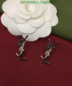 Silver gymnast-shaped earrings on red fabric background