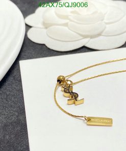 Gold pendant necklace on white floral background.