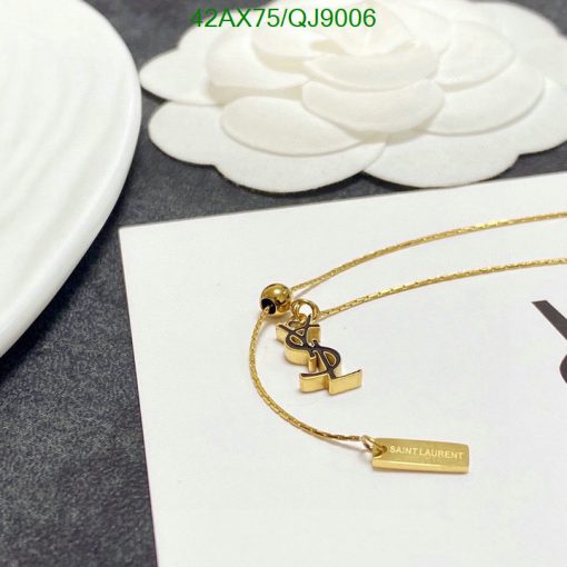 Gold pendant necklace on white floral background.