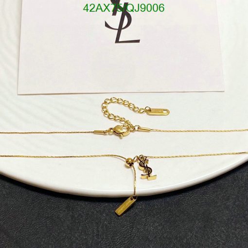 Gold necklace on white display with emblem.