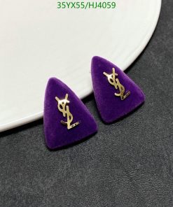 Designer logo earrings on purple velvet.