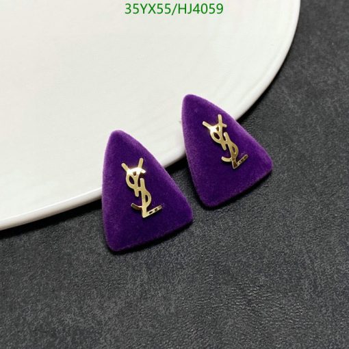 Designer logo earrings on purple velvet.