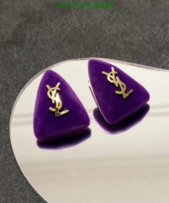 Designer logo velvet earrings on reflective surface.