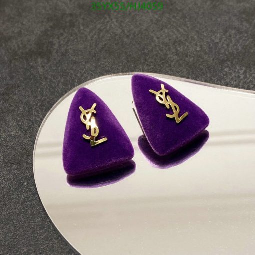 Designer logo velvet earrings on reflective surface.