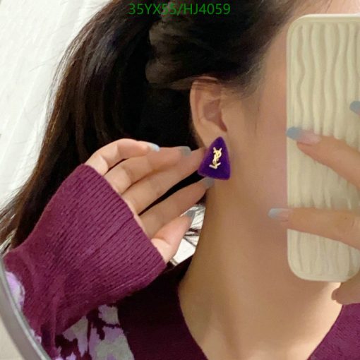 Woman showing purple earring in mirror selfie.