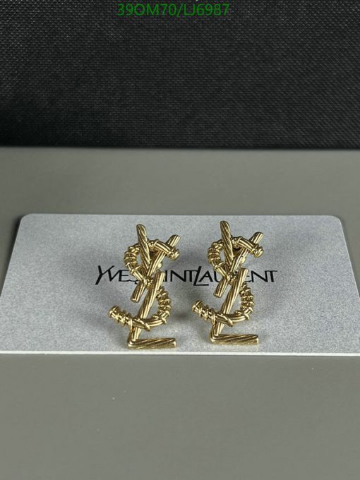 Gold cufflinks on branded holder with texture background.