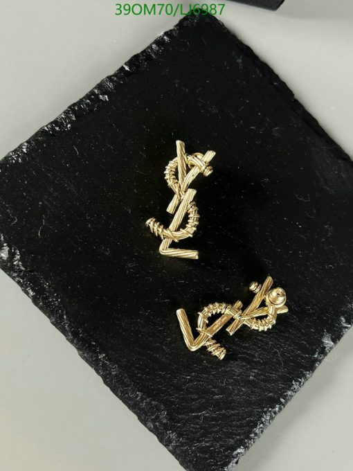 Gold designer cufflinks on black slate background.