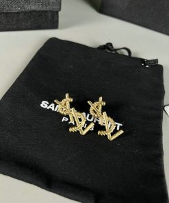 Gold cufflinks on black branded pouch.