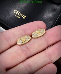 Gold oval earrings with crystals on hand.