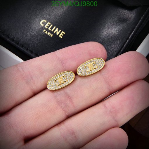 Gold oval earrings with crystals on hand.