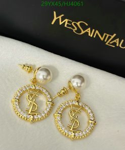 Pearl and gold logo earrings on white surface.