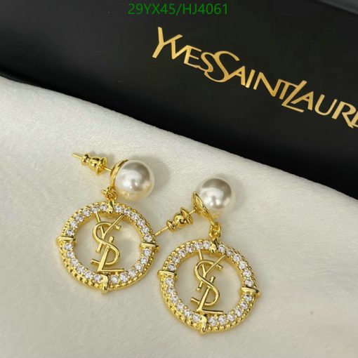 Pearl and gold logo earrings on white surface.