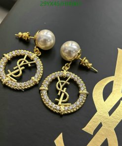 Designer pearl drop earrings with logo on black background.