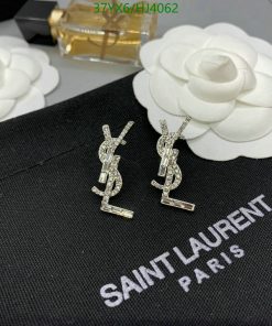 Diamond YSL logo earrings on black fabric.