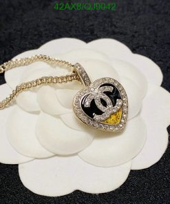 Heart-shaped pendant with chain on floral backdrop.