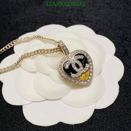 Heart-shaped pendant with chain on floral backdrop.