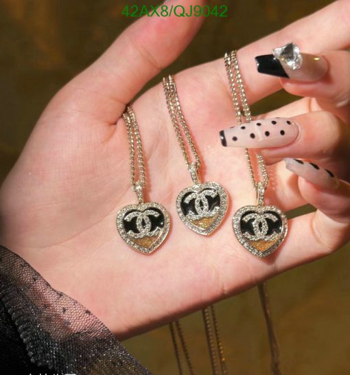 Hand holding three heart-shaped pendant necklaces.