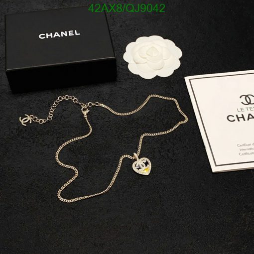 Designer necklace with packaging on black background.