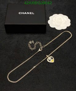 Designer necklace and packaging on black surface.