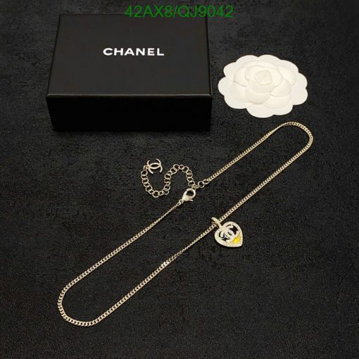 Designer necklace and packaging on black surface.