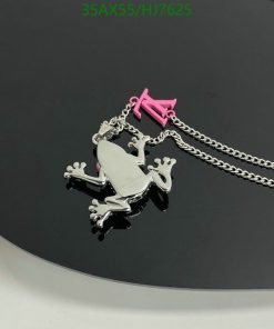 Silver frog pendant with chain on black surface