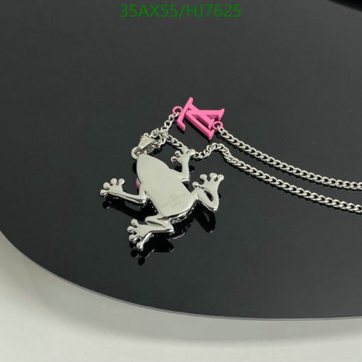 Silver frog pendant with chain on black surface